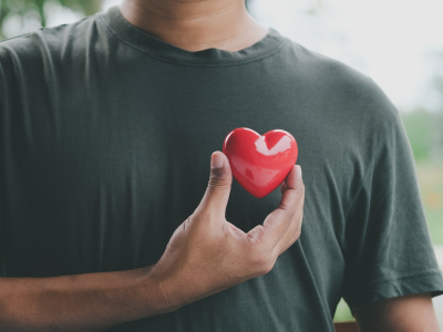 Male in green shirt holding heart prop